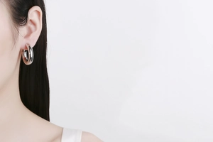 Macro view of minimalist hollow silver hoop earring with thick polished metal design
