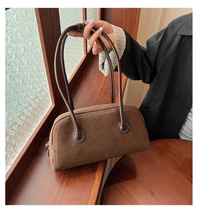 Close-up of vintage brown suede Boston handbag showing white contrast stitching detail