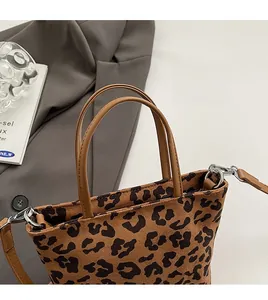 Gros plan du sac seau à motif léopard avec poignée marron et boucles métalliques