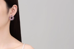 Macro shot of silver flower earrings with red teardrop stones and micro-pave crystals