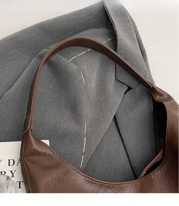 Close-up of smooth brown leather shoulder strap and premium stitching on tote bag