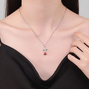 Elegant silver necklace featuring a red rose flower pendant on a female model