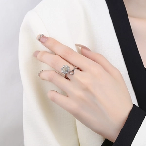 Rotating sunflower and heart silver open ring with pavé stones on a female hand