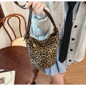 Vintage leopard print bucket bag with brown rope handles and gold pendant decoration