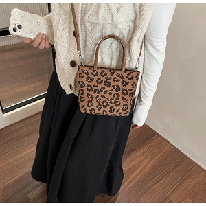 Détails du sac seau léopard avec poignées en cuir marron et bandoulière réglable