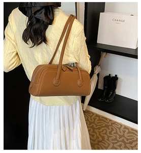 Detail of brown vintage tote bag with contrast stitching and long shoulder straps