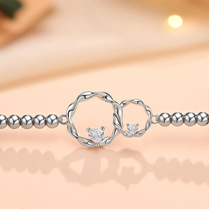 Silver beaded bracelet featuring interlocking twisted rings and heart zirconia stones