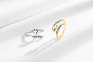 Detailed view of punk snake rings with blue gemstones and enamel in gold and silver