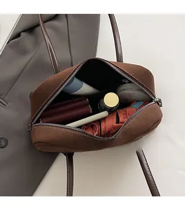 Internal view of brown suede Boston bag showing large capacity with personal items