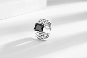 Macro shot of rectangular black zircon ring with mechanical watchband style silver band