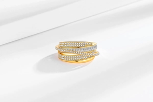 Macro view of layered gold wide band ring with pave diamonds and baguette cubic zirconia
