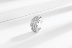 Macro shot of silver layered zircon ring on white fabric showing geometric texture