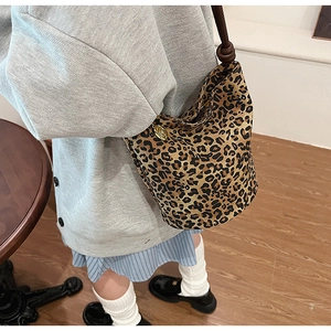 Detail of leopard print bucket bag with knotted shoulder strap and gold hardware