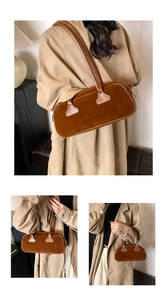Detail view of brown faux suede shoulder bag with long leather straps and sleek design