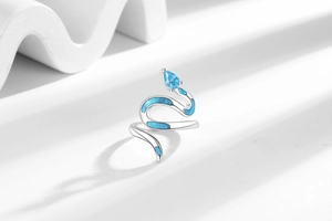 Detail of snake ring featuring light blue gemstone and blue enamel wave patterns