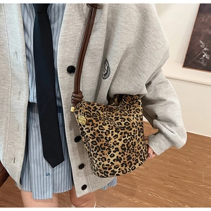 Detail of leopard print bucket bag with leather strap and golden rose charm accessory