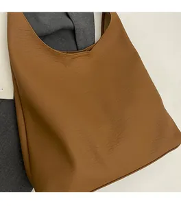 Detail shot of brown leather tote bag showing natural wrinkled texture and soft fabric