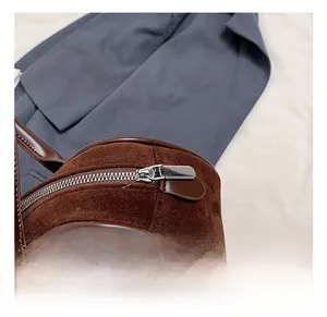 Detail shot of brown suede bag featuring premium silver zipper and leather puller