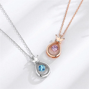 Detail of silver and rose gold crown pendant necklaces with dancing zircon stones