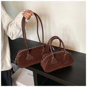 Detail of brown matte suede tote and Boston bag with leather trim and zipper closure