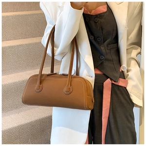 Detail of brown tote bag showing contrast white stitching and premium matte texture