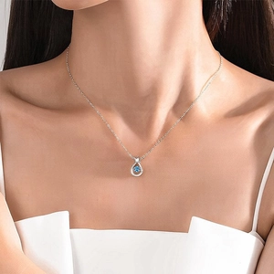 Elegant silver necklace featuring a crown-shaped water drop pendant with blue gemstone