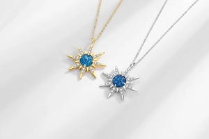 Detail of starburst pendants with blue textured stone and diamonds in gold and silver