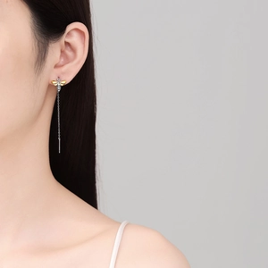Elegant bee tassel drop earrings in silver and gold plating on an Asian female model