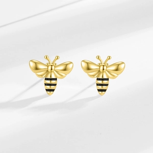 Chic gold bee stud earrings with striped heart zircon details on a soft gray background