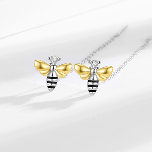 Elegant bee drop earrings with gold wings and silver chains on a minimalist white background