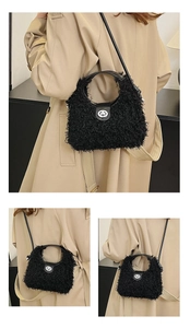 Détail du sac hobo en peluche noire avec fermoir rotatif argenté et bandoulière en cuir
