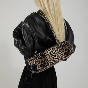 Stylish leopard print shoulder bag with black bow and heart pendant on a model