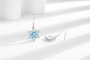 Macro shot of silver snowflake earrings with blue marquise stones and zircon details