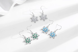 Detailed view of snowflake earrings in white, emerald green, and light blue stone finishes