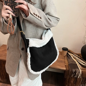 Large black suede shoulder bag with white faux fur trim shown on a model for daily commute