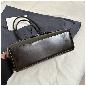 Detailed base view of dark brown faux leather shoulder bag with wide rectangular bottom