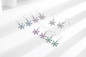 Detailed view of colorful snowflake drop earrings set with sparkling zirconia crystals
