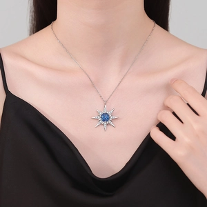 Elegant starburst pendant necklace with blue gemstone on minimalist silver chain