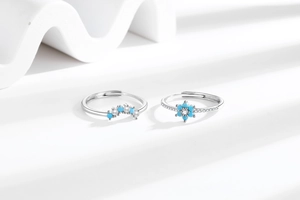 Detail of adjustable silver rings with turquoise flowers, pearls, and crown design