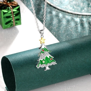 Détail macro du pendentif sapin de Noël en émail vert avec strass brillants scintillants