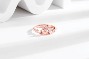 Detail of rose gold Claddagh ring with crown and heart on modern artistic background