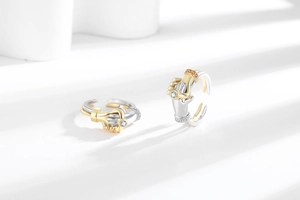 Detailed close-up of hugging hand rings with sparkling zircon and bicolor metal plating