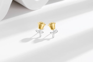 Macro detail of exquisite dual-tone rose stud earrings with gold and silver finish