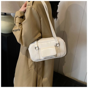 Detail of white minimalist shoulder bag with silver hardware and front pocket on trench coat