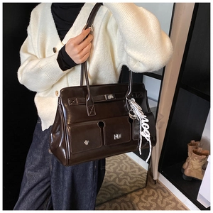 Detail of vintage brown tote bag featuring multi-pocket design and glossy wax leather finish