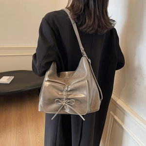 Taupe glossy faux leather crossbody bag with bow pleat design and contrast stitching