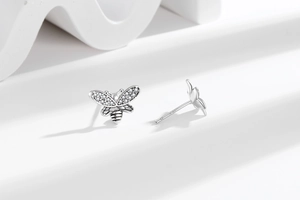 Macro shot of S925 silver bee stud earrings with sparkling cubic zirconia wing details