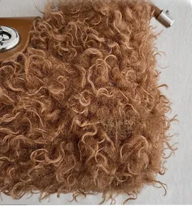 Close-up of curly brown plush fabric with silver metal twist lock and leather trim