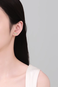 Detail of bee stud earring with cubic zirconia on gold wing worn by a model