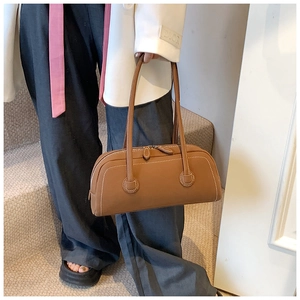 Detail of caramel leather tote bag with white contrast stitching and long shoulder handles